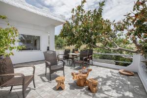 a patio with chairs and a table and trees at Libyan Sea Sunset in Kerames