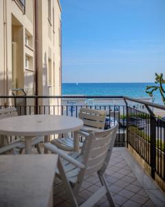 a balcony with a table and chairs and the ocean at Residence Atlantic in Alassio