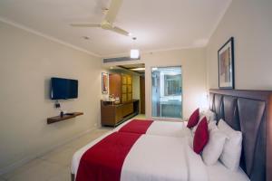1 dormitorio con 1 cama grande con almohadas rojas y blancas en The HQ, en Vasco Da Gama