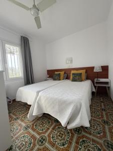 a white bedroom with a large white bed with yellow pillows at VILLA CATALUNYA in Cambrils +33 photos
