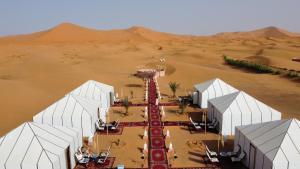 an aerial view of a desert with white domes at Morocco desert camp in Merzouga
