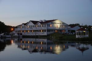 a large white building on the water at night at Weathervane Inn in Montague
