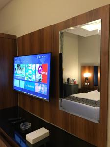 a room with a bed and a tv with a mirror at شقق ازار المخدومه in Medina