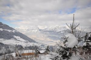 een uitzicht op een met sneeuw bedekte bergketen bij Chalet Edelweiss in Weerberg