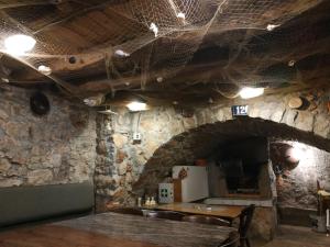 a dining room with a table and a stone wall at Apartmani Kaja, Vantačići, Otok Krk, A1 in Vantačići