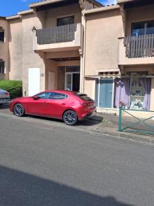 a red car parked in front of a house at Henri IV in Barbotan-les-Thermes