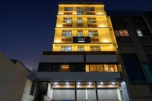 a tall building with a sign on it at night at Super Collection O Katraj Near KK Market in Pune