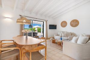 a living room with a table and chairs at Villas Menorca Sur by 3VILLAS in Son Bou