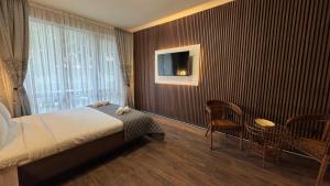 a hotel room with a bed and a table and chairs at MitProt Panorama Bay 2 Studio 93 in Sveti Vlas