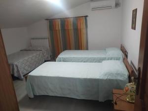 a small bedroom with two beds and a chair at La casa di Rosy in Alba Adriatica