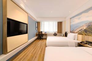 a hotel room with two beds and a flat screen tv at Atour Hotel Chongqing Jiefangbei in Chongqing