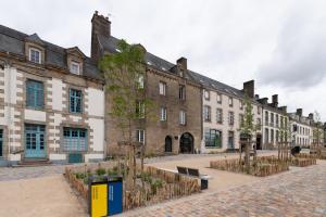 a row of large buildings in a courtyard at La Chambre Loft in Hennebont