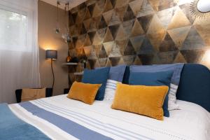 a bedroom with a bed with blue and yellow pillows at La Chambre Loft in Hennebont