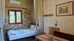 a small bedroom with a bed and a window at Georges Houses Mani in Riglia