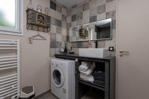 a bathroom with a washing machine and a sink at La Chambre Loft in Hennebont