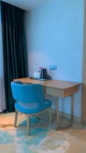 a blue chair sitting in front of a wooden desk at SENNA SUNSHINE INTERNATIONAL HOTEL in Sihanoukville