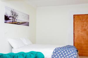 a bedroom with a white bed and a picture on the wall at RiverfrontOasis - Huge Backyard, Pool, Grand Piano in Sandton