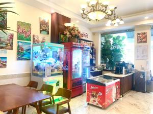 a room with a kitchen with a table and a refrigerator at Nam Xuan Premium Hotel in Da Lat