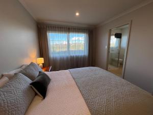 a bedroom with a large bed and a window at Parkside in Bethlehem in Tauranga