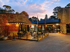 a building with a patio with tables and chairs at The Grand Oaks in Beechworth