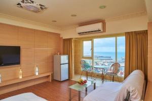 a living room with a television and a table with chairs at FJ House ABC in Keelung