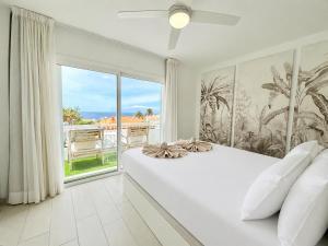 a bedroom with a large white bed and a large window at Chill Out House by Olax Rentals in Callao Salvaje +52 photos