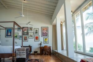 a bedroom with a bed and many pictures on the wall at Villa Sayura by TONIK, Boossa - Beachfront in Busse