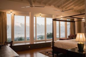 a bedroom with a bed with a view of the ocean at Villa Sayura by TONIK, Boossa - Beachfront in Busse