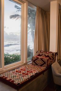 a window seat with a view of the ocean at Villa Sayura by TONIK, Boossa - Beachfront in Busse