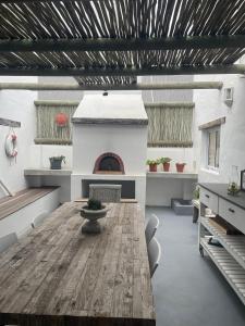 a living room with a wooden table and a fireplace at Bougain Villa in Paternoster