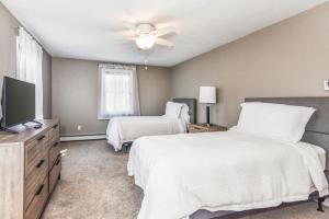 a bedroom with two beds and a flat screen tv at Corn Hill Ranch in Falmouth