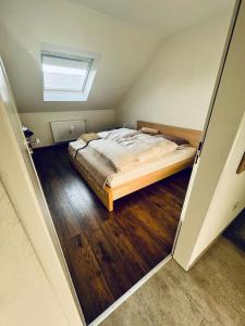 a bedroom with a bed in a room with wooden floors at Kiebitz Schmuckstück in Walibo in Lippstadt