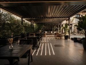 an outdoor patio with tables and chairs and awnings at The Local House Alaçatı in Alaçatı