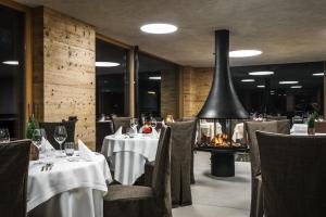 a restaurant with tables and chairs and a fireplace at Gourmet Hotel Gran Ander in Badia
