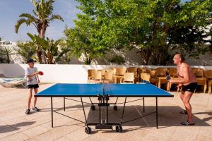 a man and a boy playing a game of table tennis at Zodiac Hôtel & Aqua Park in Hammamet