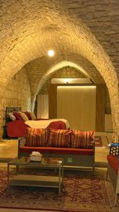 a room with two beds and a couch and a table at Bayt Broud in Gharīfah