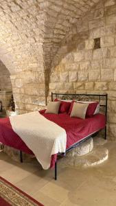 a bedroom with a bed in a stone wall at Bayt Broud in Gharīfah