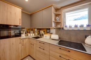 a kitchen with wooden cabinets and a window at Seefeld ALPIN Apartments in Seefeld in Tirol +88 photos