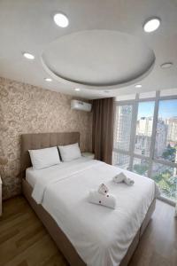 a bedroom with a large white bed with a large window at dupleqs batumi daRia in Angisa