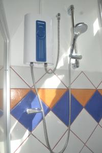 eine Dusche in einem Bad mit Fußböden in der Unterkunft Hotel Arenal by Regina in Fortuna
