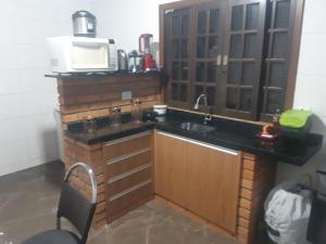 a kitchen with a sink and a microwave at Chacara barro branco in Foz do Iguaçu