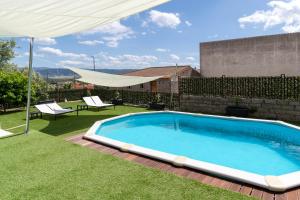a swimming pool in a yard with a umbrella at Domo Cadò in Berchidda