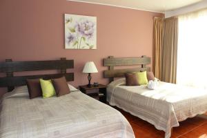 A bed or beds in a room at Hotel Arenal By Regina