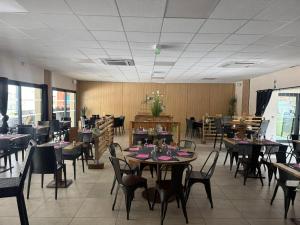 a dining room with tables and chairs in a restaurant at Camping La Marmotte in Ax-les-Thermes
