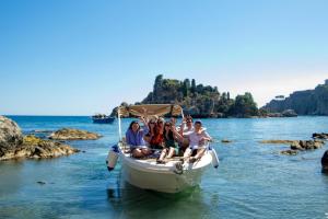 a group of people sitting on a boat in the water at Hugo Experience - Taormina boat tour in Taormina