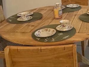 a wooden table with plates and cups on top of it at 46 Minerva Avenue in Pennington