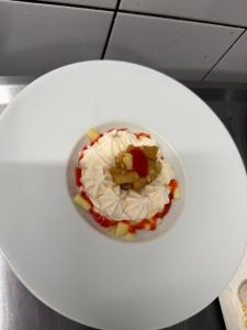 a white plate with a dessert on a table at Logis Hôtel Auberge Lukaïna in Urrugne