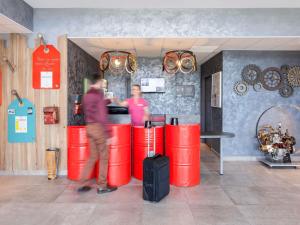 a couple of people standing at a counter in a store at ibis Styles Vierzon in Vierzon +136 photos