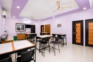 a dining room with tables and chairs and a ceiling at Hotel I Live Inn in Chennai