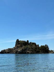 an island in the middle of the water at Hugo Experience - Taormina boat tour in Taormina +7 photos